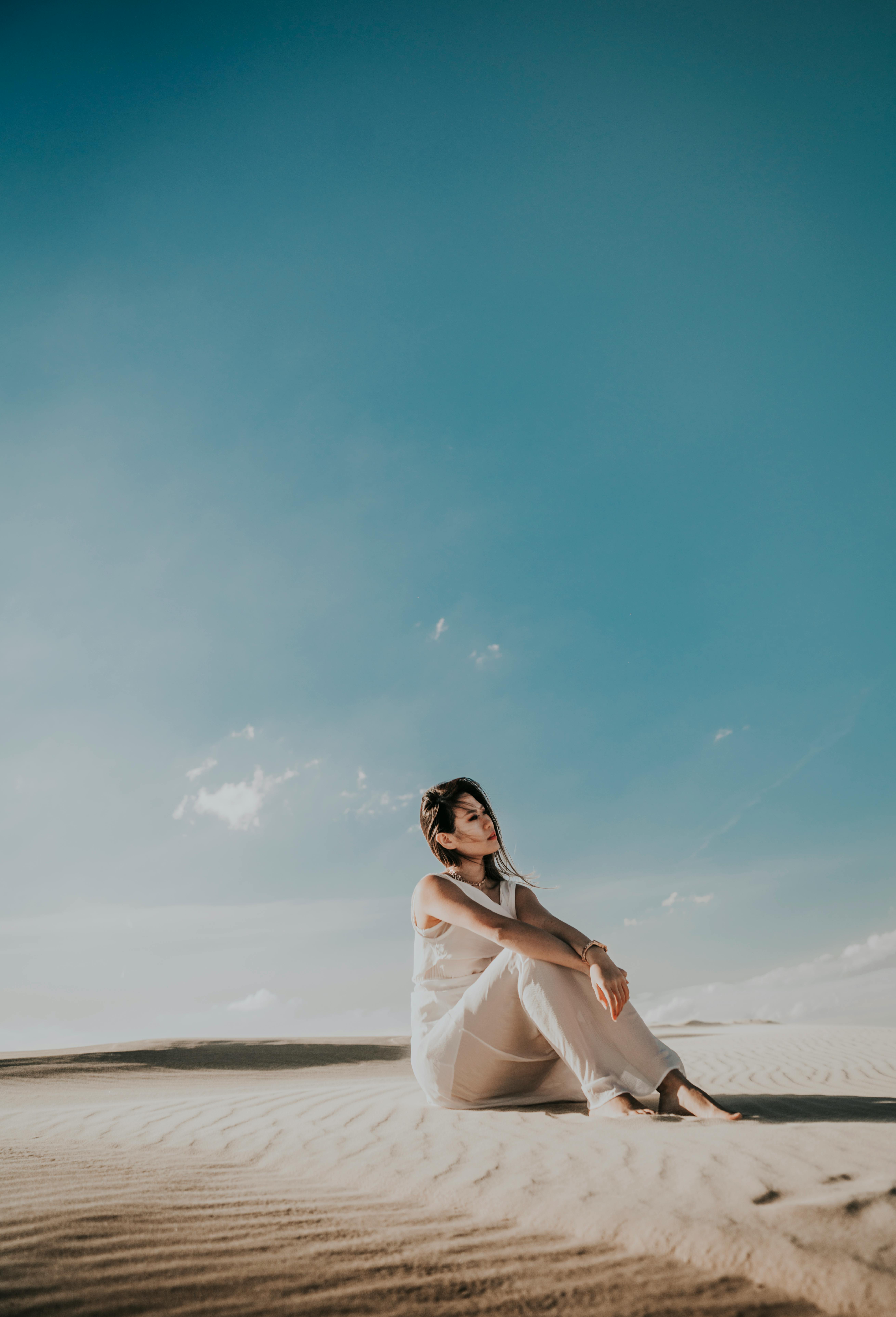 Wedding photographer updating website during off-season, focused and working on laptop with camera beside her