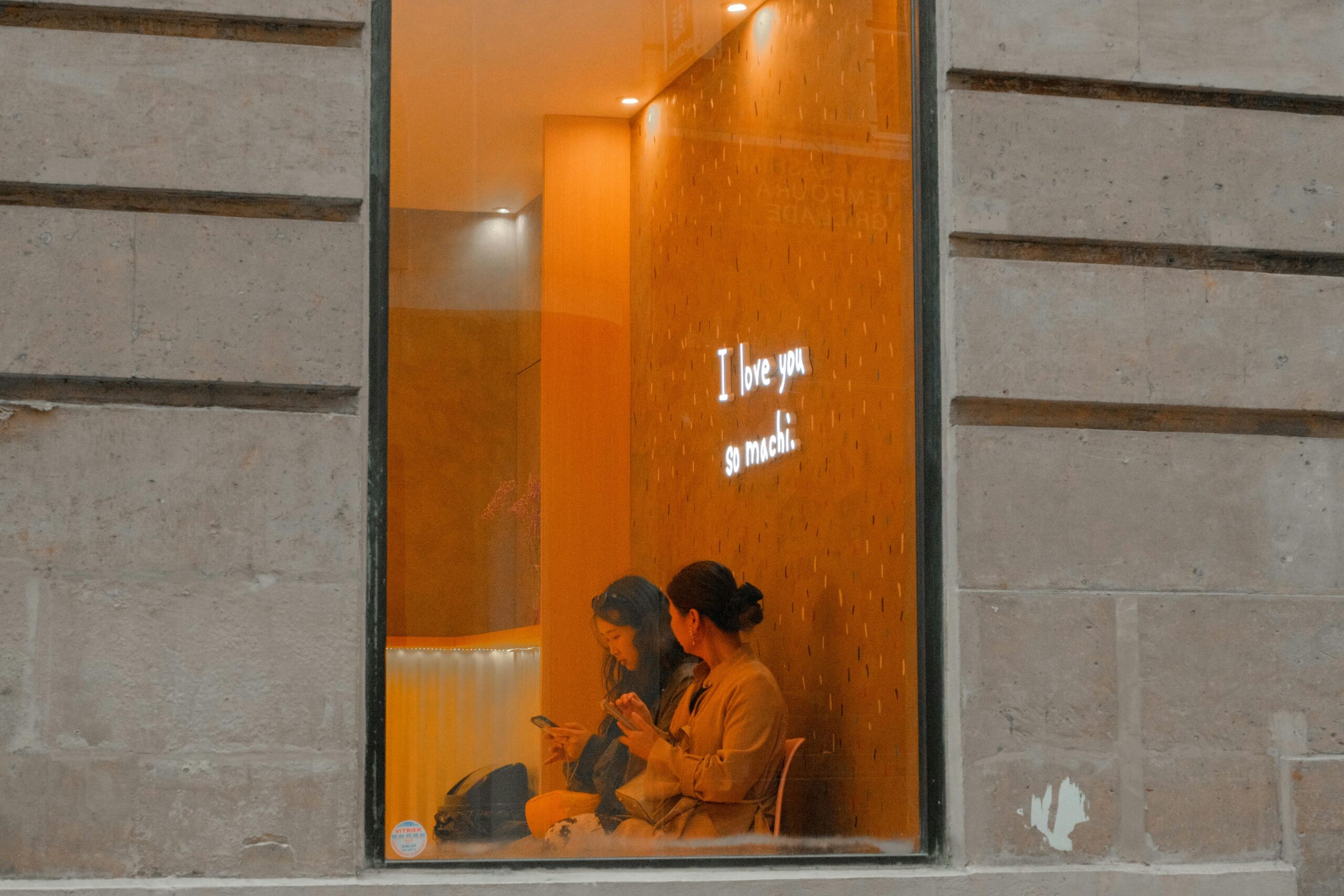 A bride using ChatGPT on her phone while wedding inspiration is pulled up on a laptop, with a wedding photographer’s blog post visible in the background.